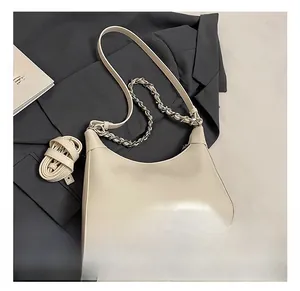 Detail of cream hobo bag on grey blazer with silver chain and adjustable straps