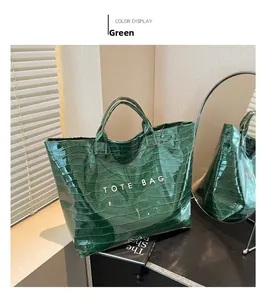 Detail of dark green tote bag featuring crocodile embossed pattern and glossy finish