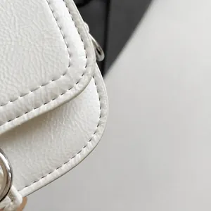 Detaillierte Makroansicht der weißen Satteltasche mit hochwertiger Lychee-Textur und Naht
