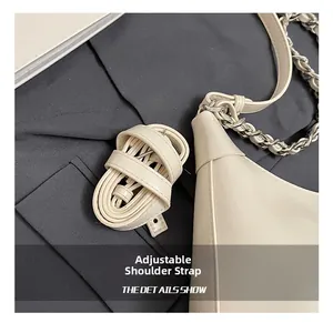 Detail of adjustable leather strap and silver chain on a premium tote shoulder bag