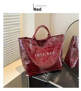 Detail of red crocodile pattern patent leather tote bag with white TOTE BAG text print