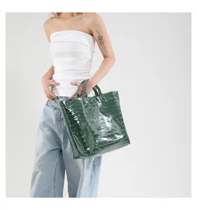 Crocodile pattern dark green tote bag shown on a model with stylish streetwear outfit