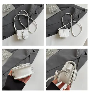 Makro-Details der weißen Mini-Satteltasche mit strukturiertem Leder und Silberbuckle