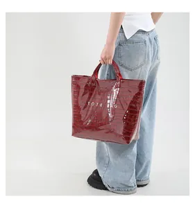 Model holding wine red crocodile pattern tote bag with white TOTE BAG text print