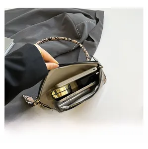 Vue de dessus de l'intérieur du sac serpent montrant la capacité pour maquillage et mobile