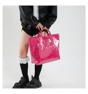 Close-up of bright pink tote bag with crocodile texture and white TOTE BAG print