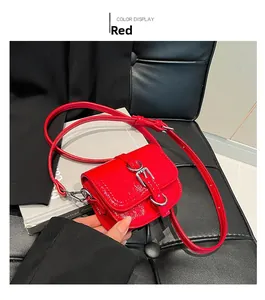 Detailaufnahme der roten Mini-Satteltasche aus Lackleder mit silberner Schnalle