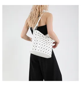 Détail du sac seau blanc avec rivets argentés et bandoulière réglable sur le mannequin