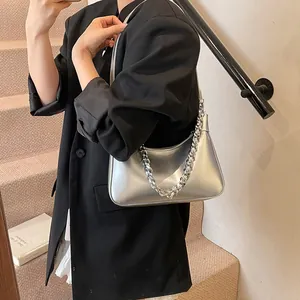 Metallic silver large tote bag with chain strap shown on model in stylish urban setting
