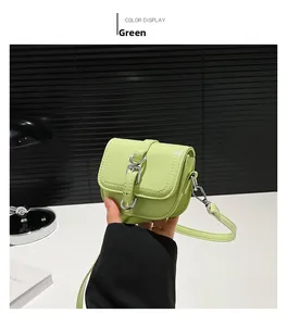 Detailansicht einer grünen Mini-Satteltasche auf weißem Tisch mit moderner Deko