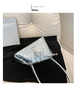 Détail de la texture crocodile argentée et de la fermeture éclair du sac sous le bras