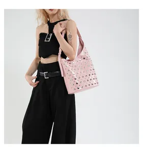 Gros plan du sac Hobo rose brillant avec clous argentés et bandoulière réglable chic