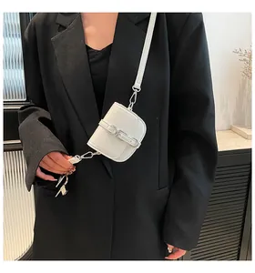 Nahaufnahme der weißen Mini-Umhängetasche mit Litchi-Struktur auf schwarzem Blazer