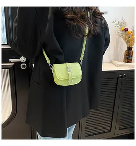 Detail-Rückansicht einer mini lindgrünen Leder-Satteltasche auf schwarzem Sakko