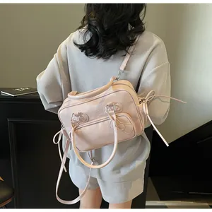 Macro shot of light pink glossy pillow bag featuring adjustable straps and polished finish