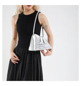 Détail du sac à main triangulaire argenté avec gaufrage crocodile et fini brillant