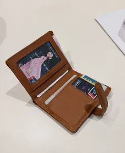 Vista dettagliata del portafoglio in pelle marrone con fessure per carte e capacità