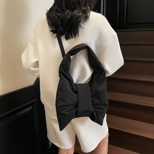 Fashionable black padded bow shoulder bag for women with minimalist aesthetic design