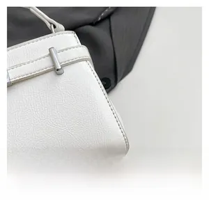 Close-up of white textured synthetic leather with silver metal buckle detail