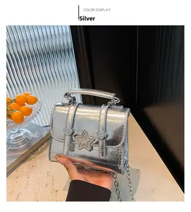 Nahaufnahme der silbernen Mini-Tasche mit Metallic-Falten, 3D-Stern und Kettenriemen