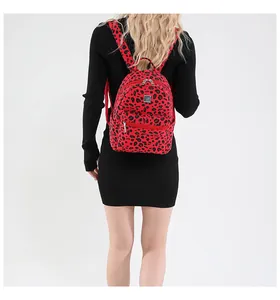 Détail du sac à dos léopard rouge sur modèle montrant les bretelles et la texture design