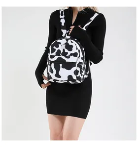 Détail d'un petit sac à dos à motif vache et zébré porté par un mannequin
