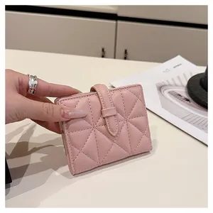 Dettaglio del portafoglio in pelle trapuntata rosa con cuciture a triangolo e fibbia chiusa