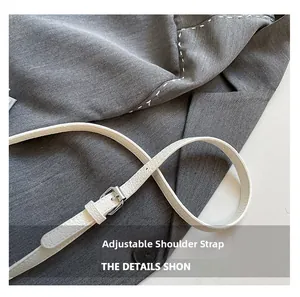 Détail de la bandoulière réglable en cuir blanc avec boucle argentée sur petit sac carré