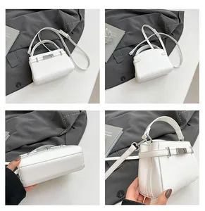 Detail view of white lychee leather handbag with silver metal lock and textured finish