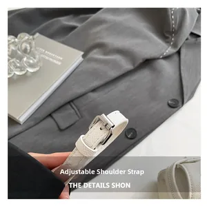 Details des verstellbaren weißen Gurts mit silberner Metallschnalle an der Handtasche