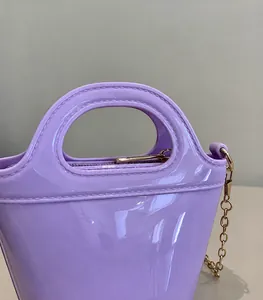 Detailed macro view of purple glossy jelly bag featuring gold zipper and metal chain strap