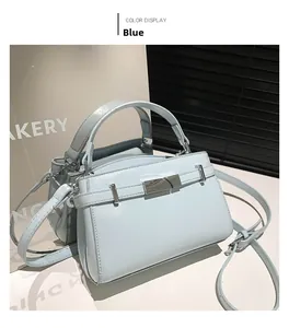 Detail of light blue patent leather handbag with silver buckle and accordion side gussets