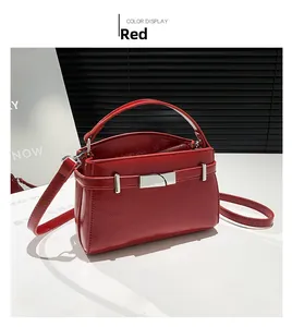 Detailed view of red glossy patent leather handbag with silver metallic buckle and strap