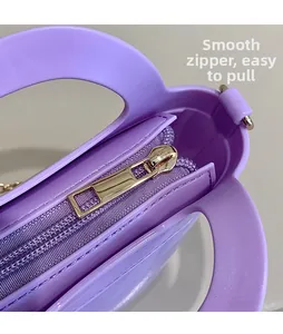 Close-up of a smooth gold metal zipper on a purple jelly-style handbag with a sleek finish