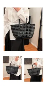 Detail of black hollow woven tote bag featuring glossy waterproof material and sturdy handles