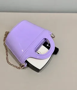 Internal view of purple jelly handbag showing capacity for cosmetics and golden chain