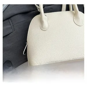 Gros plan sur la texture grainée blanche du sac à main montrant le cuir de qualité