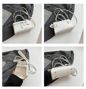 Detailansicht einer weißen Leder-Henkeltasche mit silbernen Schutzfüßen am Taschenboden