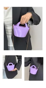Close-up of glossy lilac jelly bag with metallic gold chain and polished surface texture