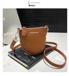Détail du sac bandoulière en cuir grainé marron avec fermeture éclair argentée