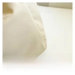 Close-up of premium cream nylon fabric showing fine texture and soft stitching details