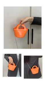 Macro detail of vibrant orange jelly handbag with glossy finish and gold chain strap