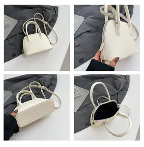 Vue détaillée du sac à main blanc motif litchi avec poignées et bandoulière réglable