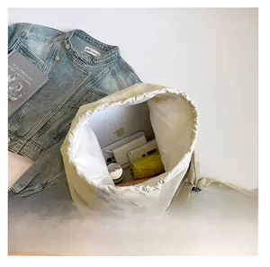 Interior storage view of spacious cream drawstring nylon tote bag with daily essentials