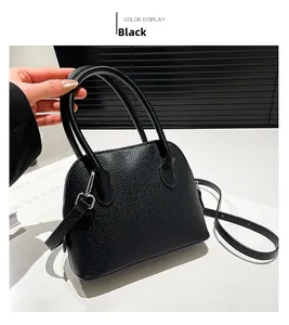 Gros plan d'un sac à main noir en cuir grainé avec bandoulière réglable et amovible