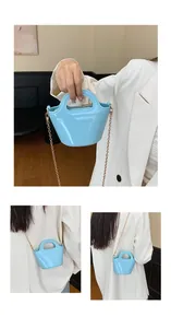 Macro view of light blue jelly handbag showing glossy texture and gold chain detail