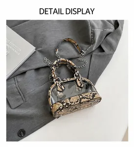 Détail du sac à main en PVC transparent et cuir motif serpent avec clous en métal