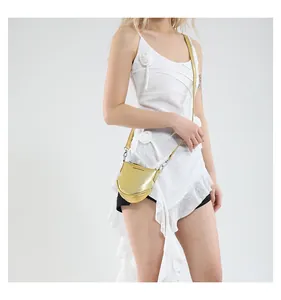 Vue détaillée d'un sac besace doré métallisé avec l'inscription Fashion & Bags