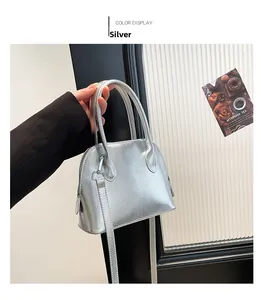 Détail du sac bandoulière argenté avec grain de litchi et poignées en métal