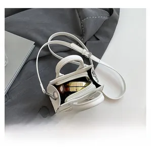 Interior view showing the capacity of a white faux leather crossbody bag with cosmetics